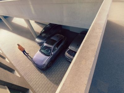 Hyundai KONA Electric parkeert achteruit in een garage tussen twee auto's.