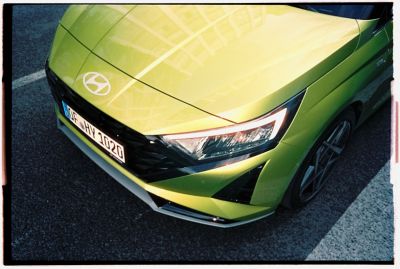 Die Front eines grünen Hyundai i20, von oben gesehen, mit freiem Blick auf den linken Scheinwerfer.