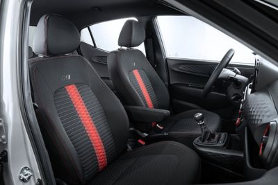 Die Vordersitze des Hyundai i10 N Line mit roten Akzenten.