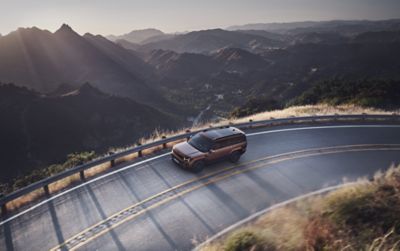 De Hyundai Santa Fe Hybrid rijdt op een bochtige bergweg. 