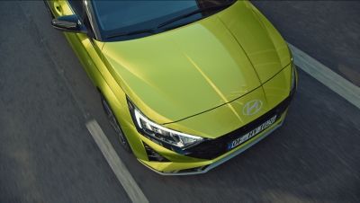 Die Front eines grünen Hyundai i20 von oben gesehen auf einer Straße.