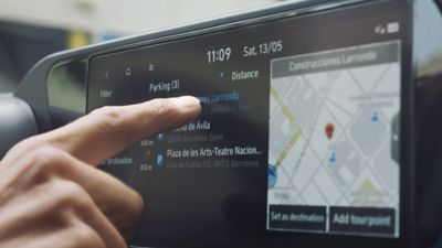 Der Finger einer Person auf dem Touchscreen des Hyundai i20.