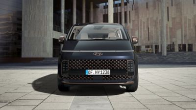 Foto van de futuristische grille en LED-koplampen van de STARIA Hybrid Premium.