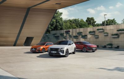 Modely i30 Kombi, TUCSON a KONA stojící u moderní budovy